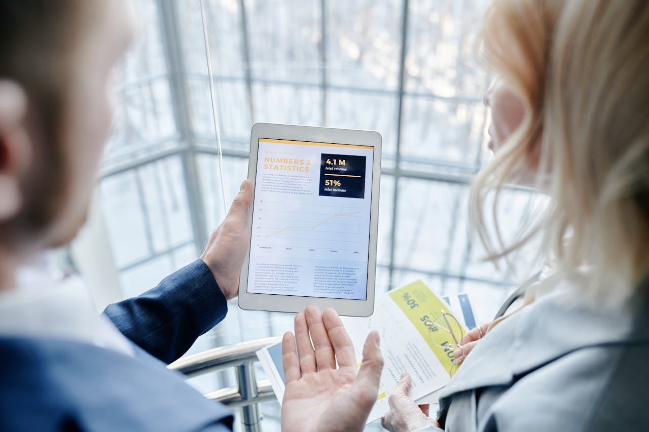 Sales team reviewing business statistics on a tablet